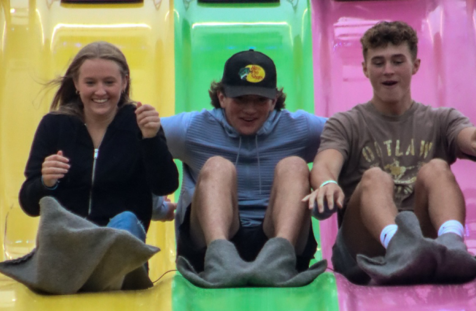 teenagers going down a slide